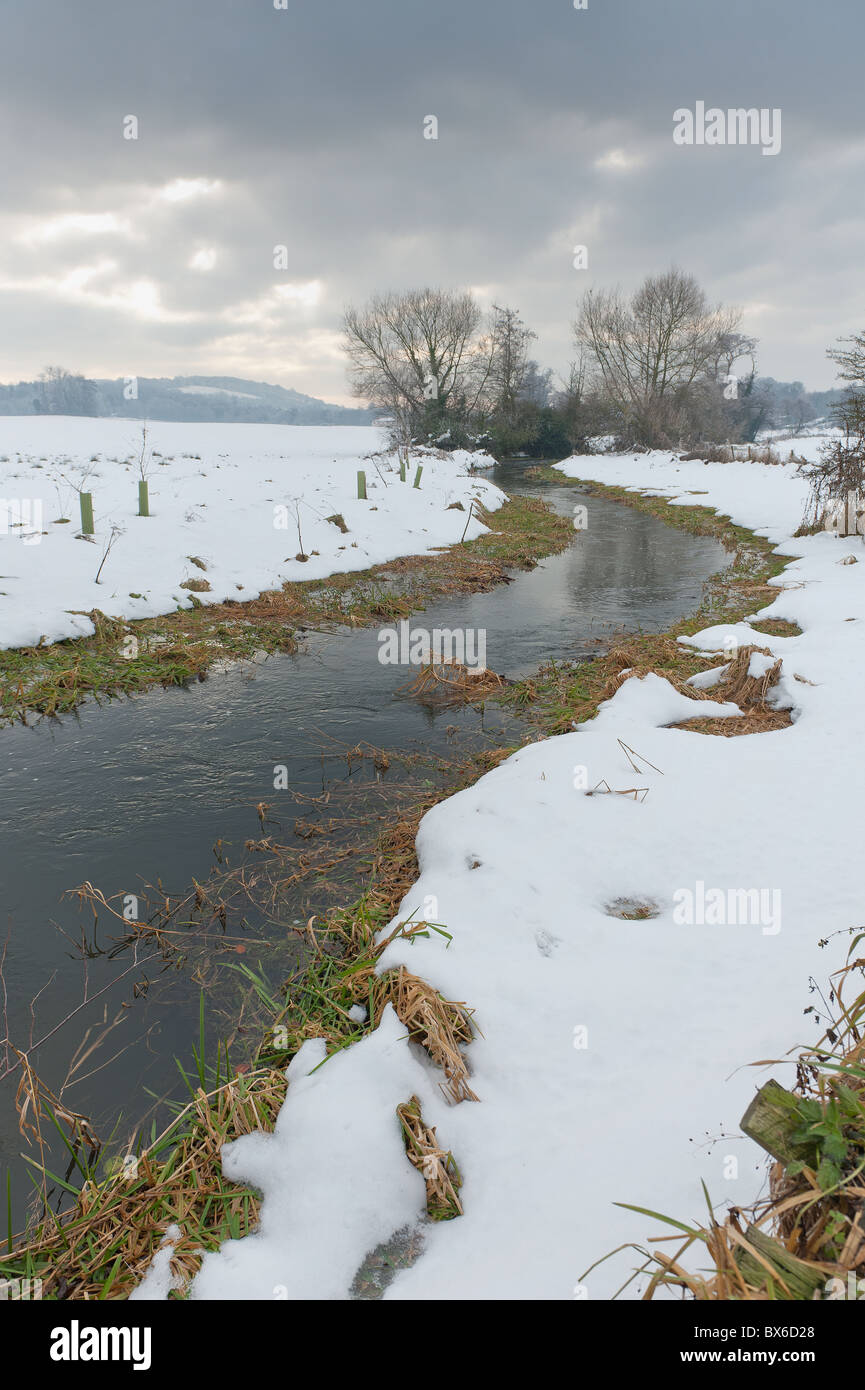 Neve minacciose nuvole nel cielo offuscare la terribilmente freddo fiume Darent Foto Stock