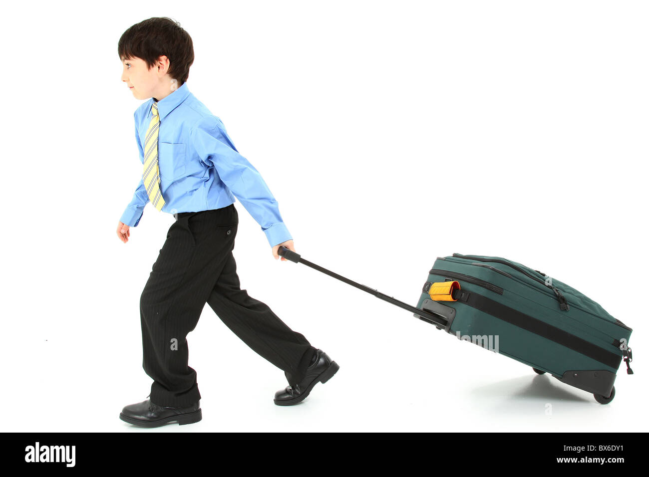 Adorabili e sette anni di Francese antico american boy tirando grande valigia su sfondo bianco. Foto Stock