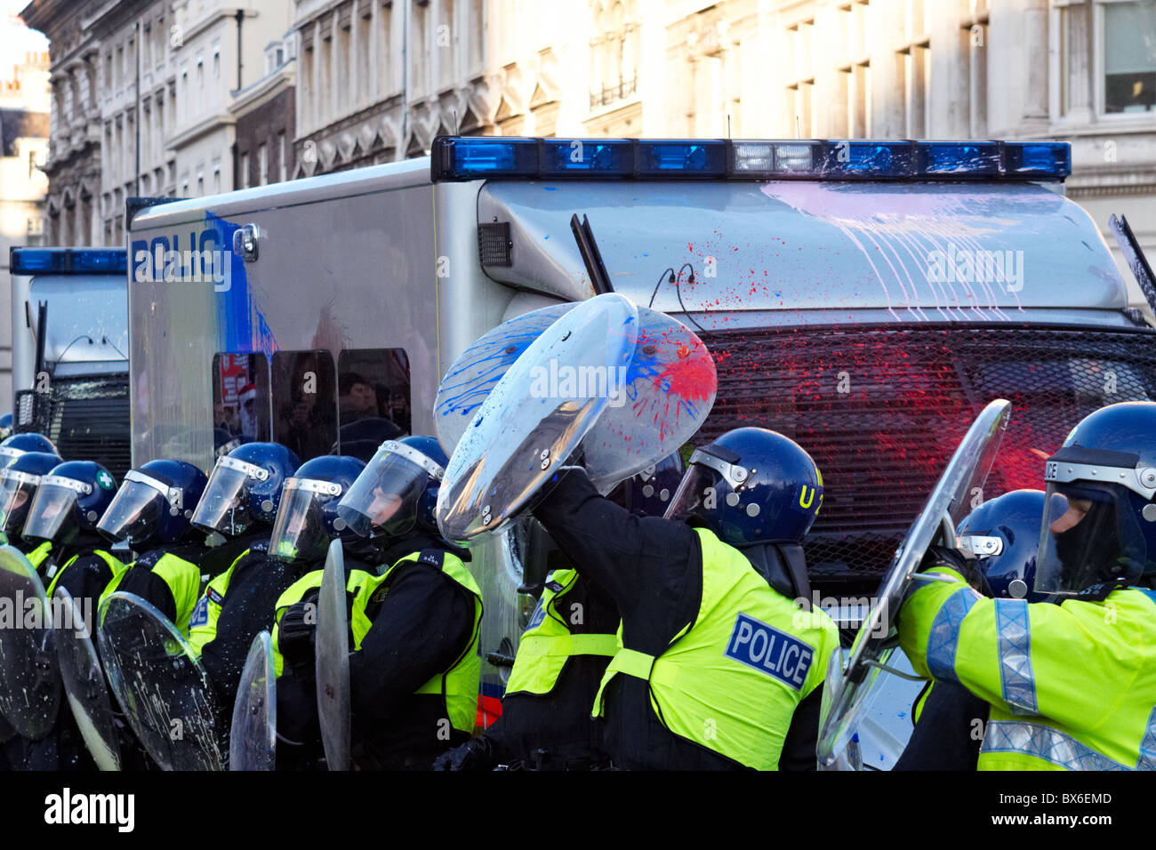Londra, Regno Unito. Cooperazione di polizia con scudi antisommossa sono opener con bombe di vernice durante il quarto round di proteste degli studenti Foto Stock