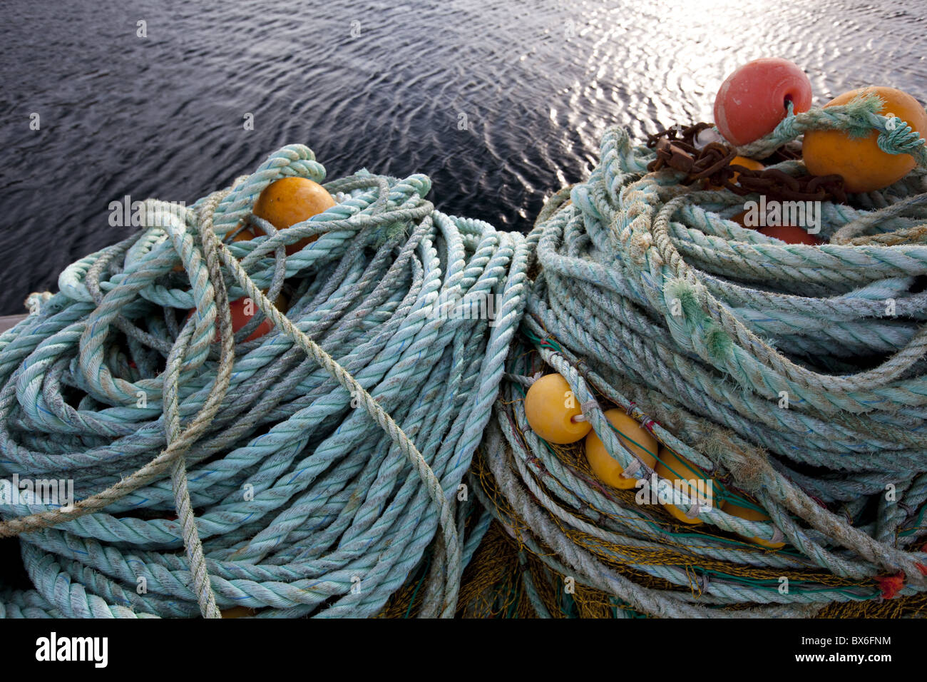 Funi e reti da pesca e galleggia sulla banchina del porto di Sto village, isola di Langoya, arcipelago Vesteralen, Norvegia Foto Stock