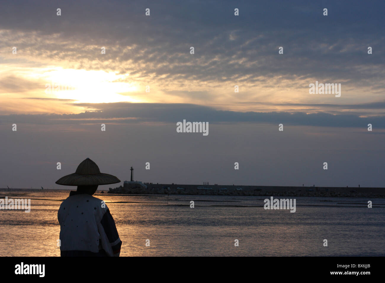 Un uomo si erge accanto all'acqua nel porto di AnPing in maggiore Tainan, Taiwan. Foto Stock