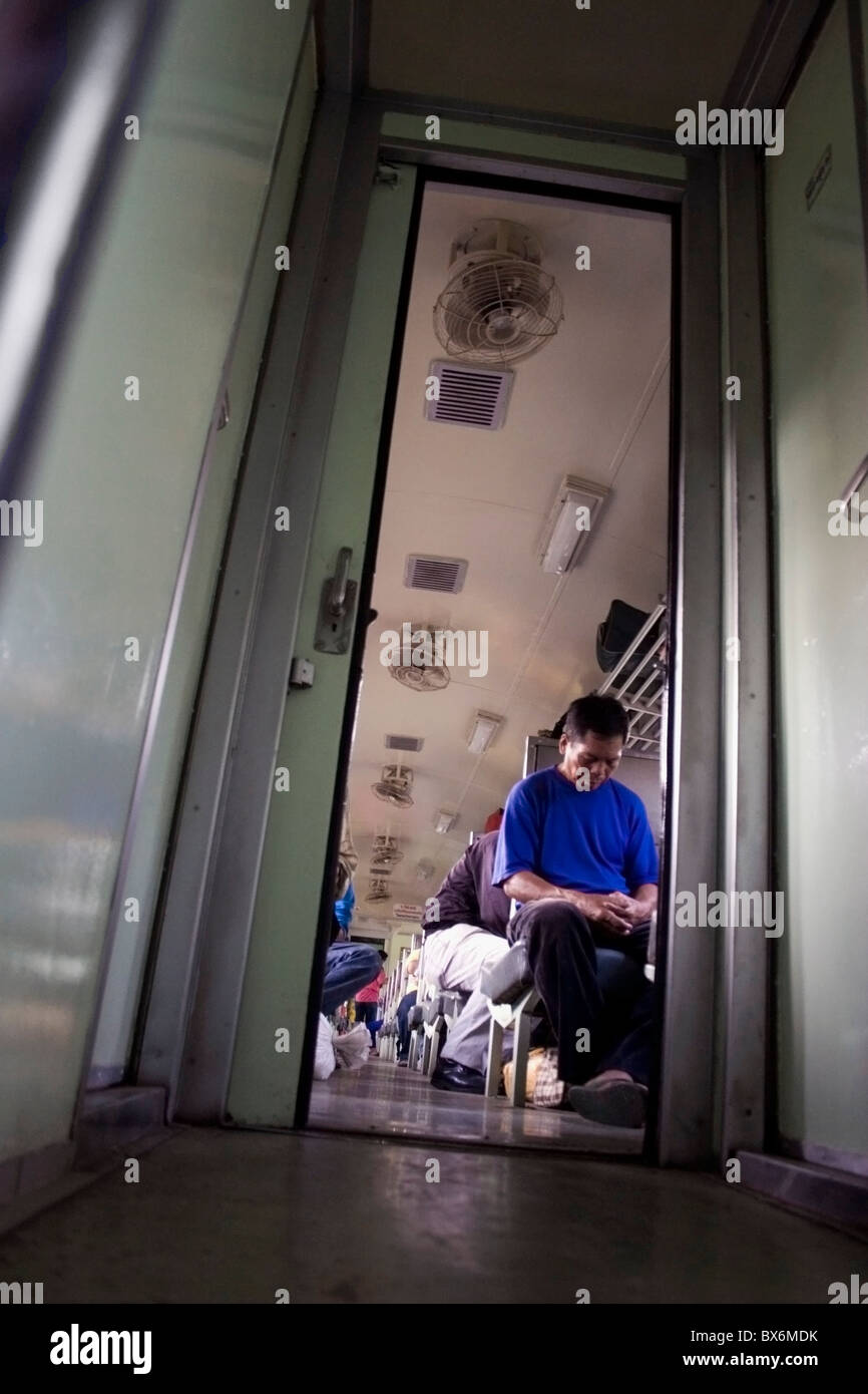 Le persone viaggiano su un legato di Bangkok treno passeggeri in Ubon Ratchathani Provincia, Thailandia. Foto Stock