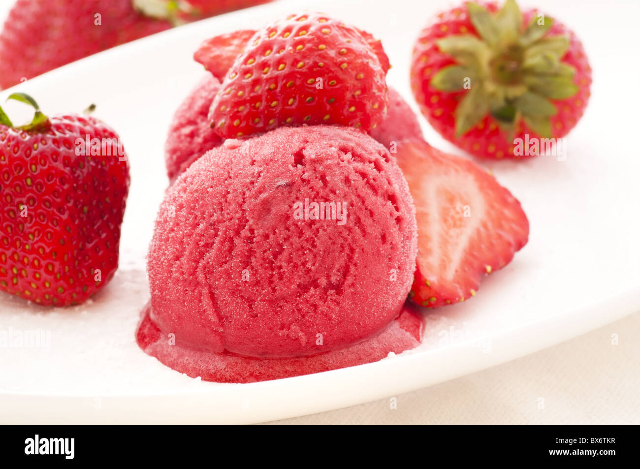 Fragola ghiaccio con fragole, in primo piano su una piastra bianca Foto Stock