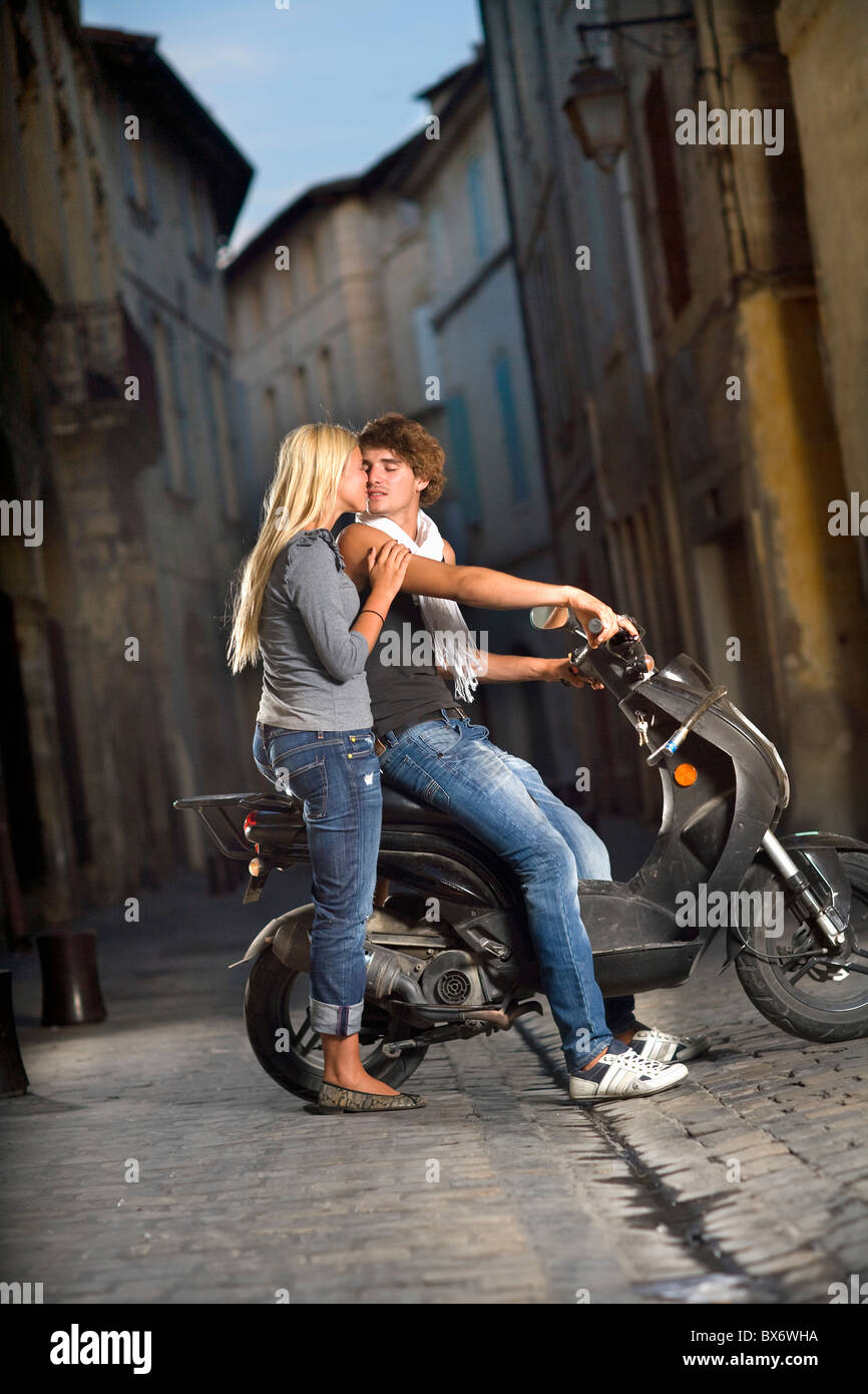 Coppia giovane kiss su scooter in strada Foto Stock