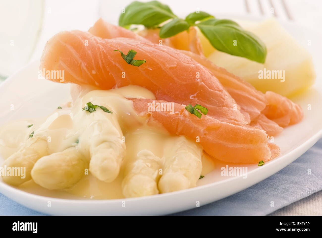 Asparagi con fette di salmone e patate su una piastra bianca Foto Stock