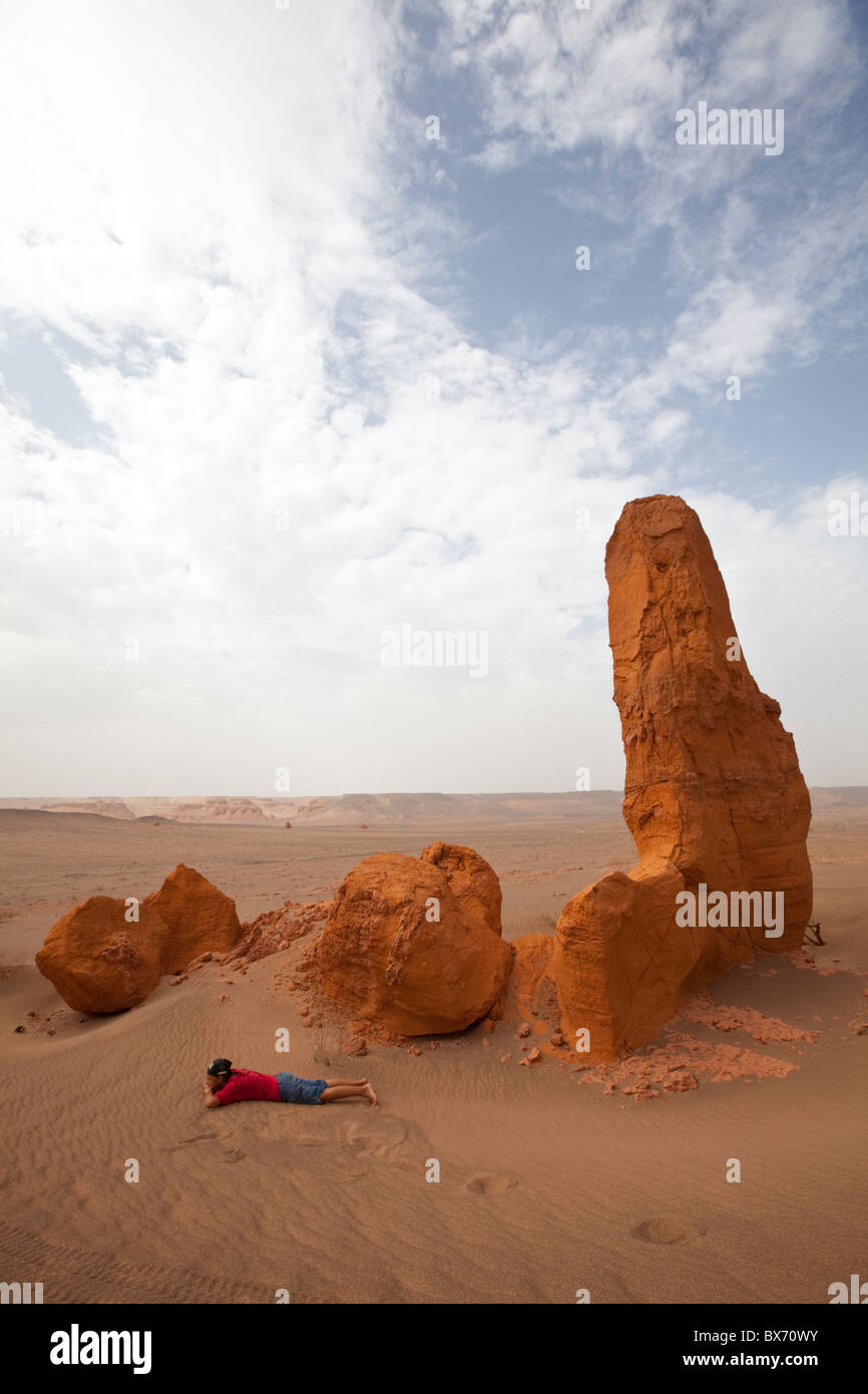 Rilassatevi ragazza vicino a rock in Khermen Tsav, , Gurvansaikhan National Park, Sud Il deserto del Gobi e Mongolia Foto Stock