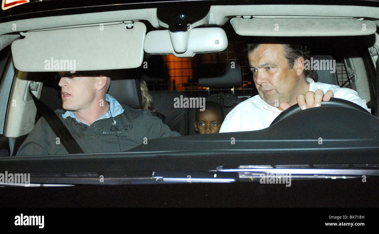 Negli Stati Uniti la musica pop Madonna icona centro sinistra parzialmente coperto da una sede arriva con uno dei suoi figli in una limousine al lussuoso Foto Stock