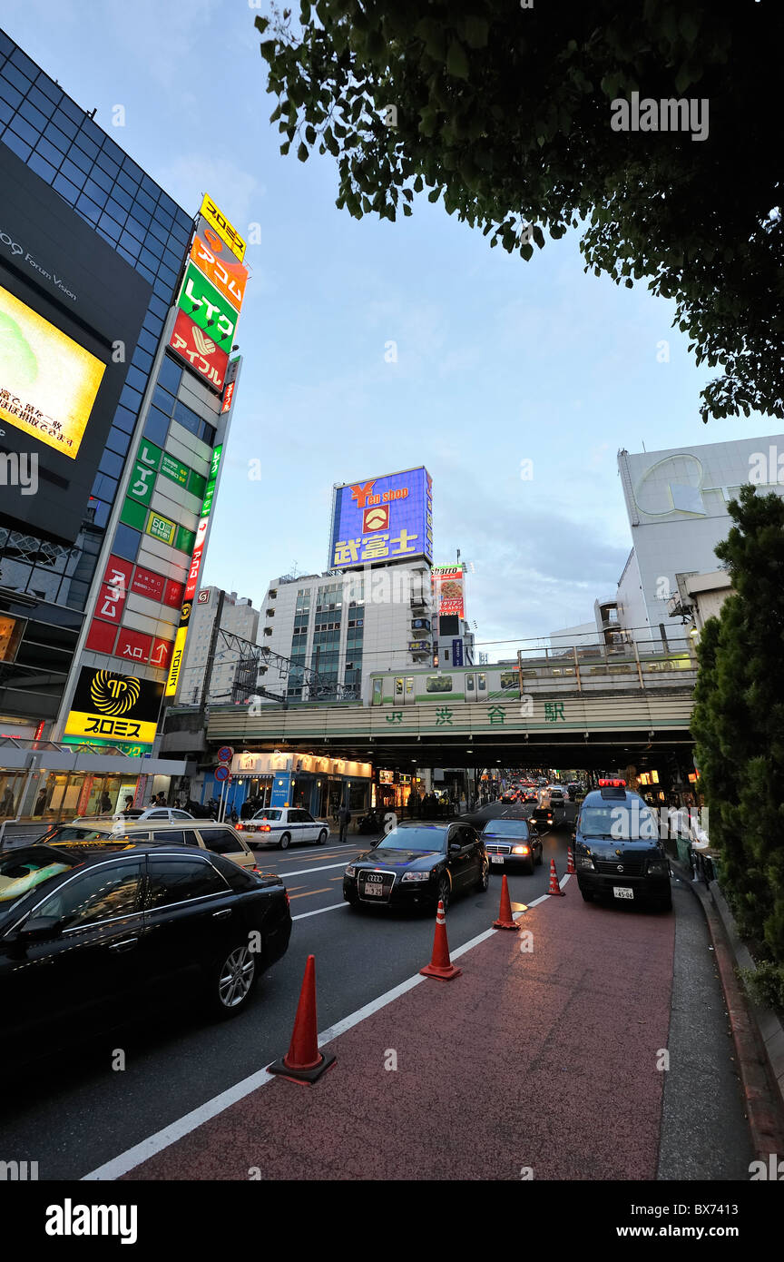 La linea JR treno attraversando ponte a Shibuya Crossing al tramonto, Tokyo, Giappone Foto Stock
