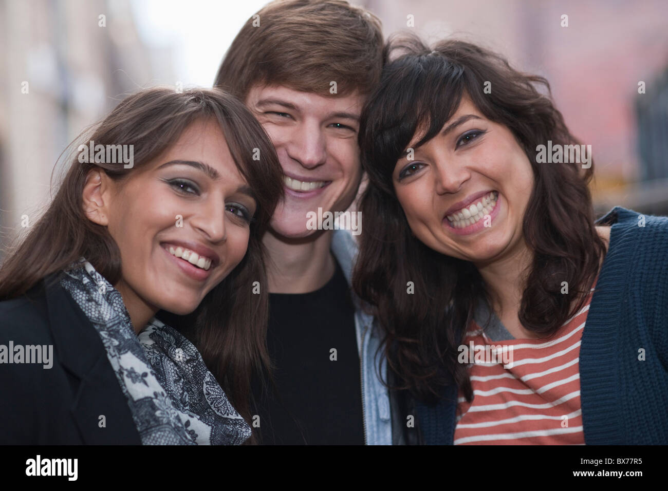 3 amici sorridere alla telecamera in strada Foto Stock