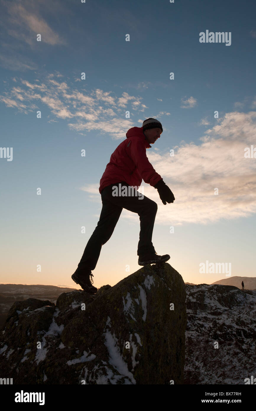 Un alpinista sulla rupe Todd vertice nel distretto del lago, UK, al tramonto. Foto Stock