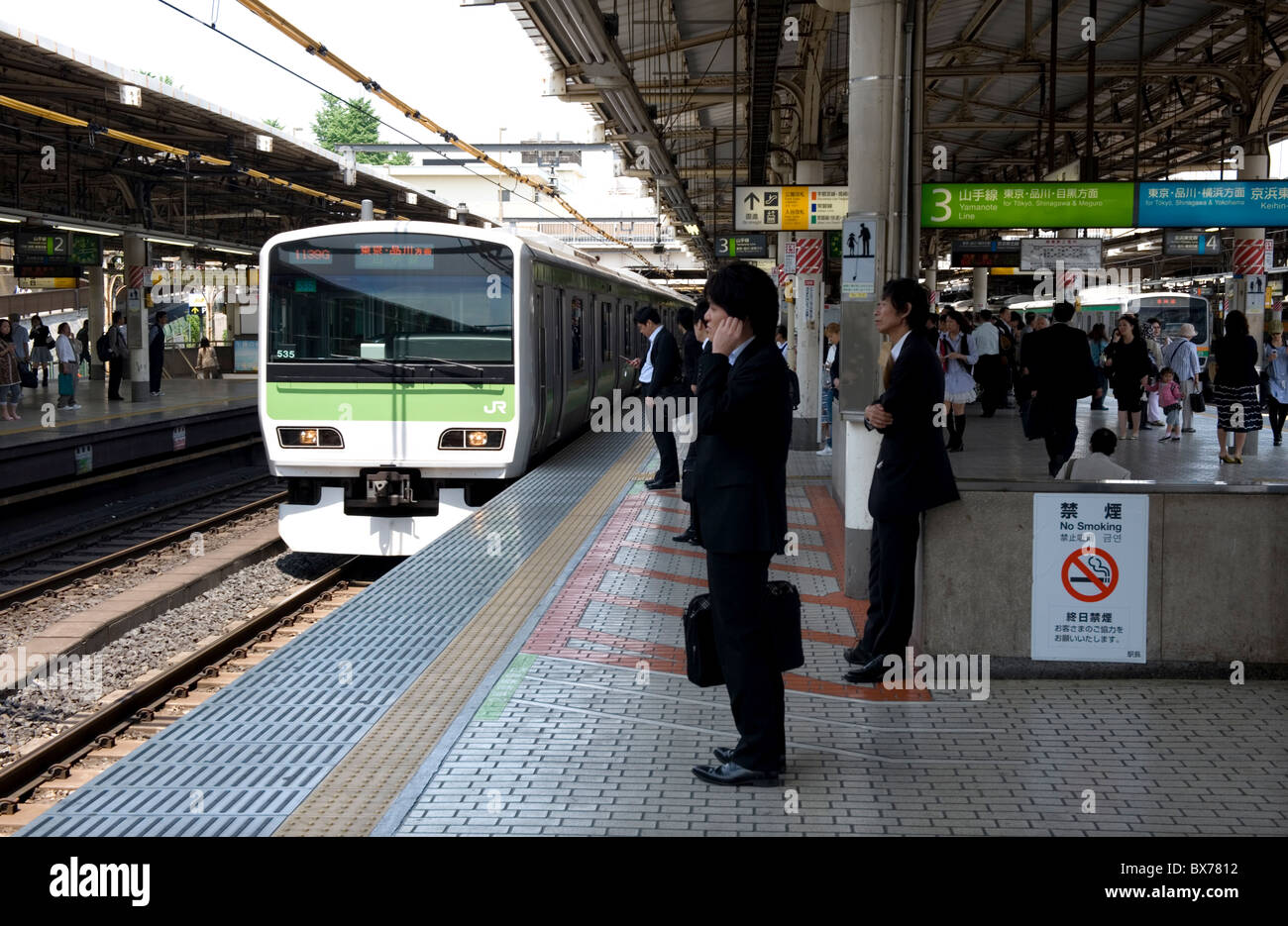 Imprenditore in attesa per il loop di Yamanote Line solo in treno arrivando alla stazione JR Ueno stazione ferroviaria in Tokyo, Giappone, Asia Foto Stock