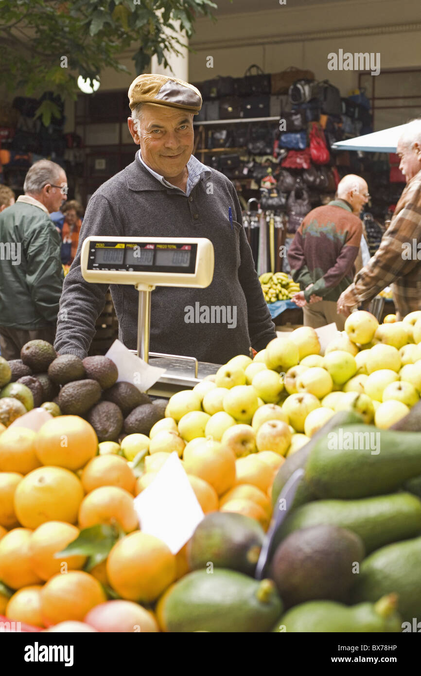 Un frutto in stallo titolare lavora al Mercado des Lavradores nel centro di Funchal, Madeira, Portogallo, Europa Foto Stock