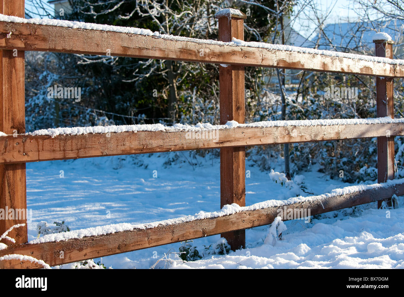 Una coperta di neve pupazzo di neve staccionata in legno a guardia di un paradiso per gli sport invernali. Foto Stock