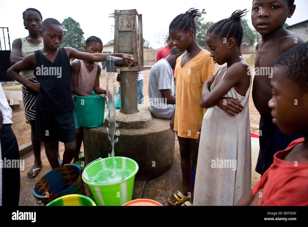 Gli abitanti di un villaggio di pompare acqua da un quartiere ben in Kakata, Libera, Africa occidentale. Foto Stock