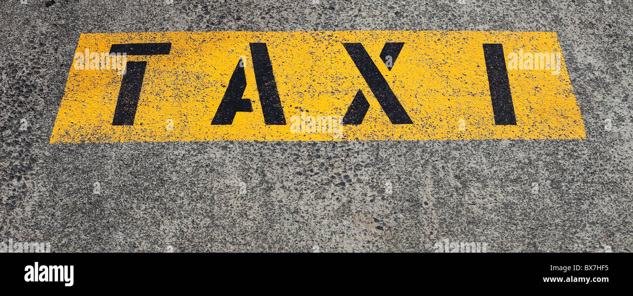 Il termine taxi scritto sull'asfalto segnando un taxi. Foto Stock