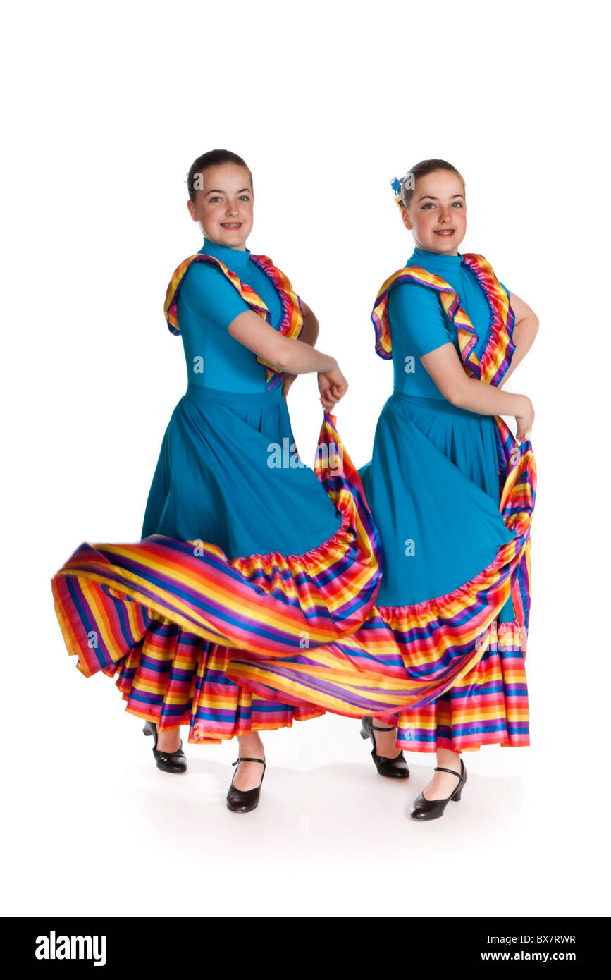 Studio shot della giovane e bella gemelli identici in colorate nazionale messicana dancing costume, contro uno sfondo bianco Foto Stock