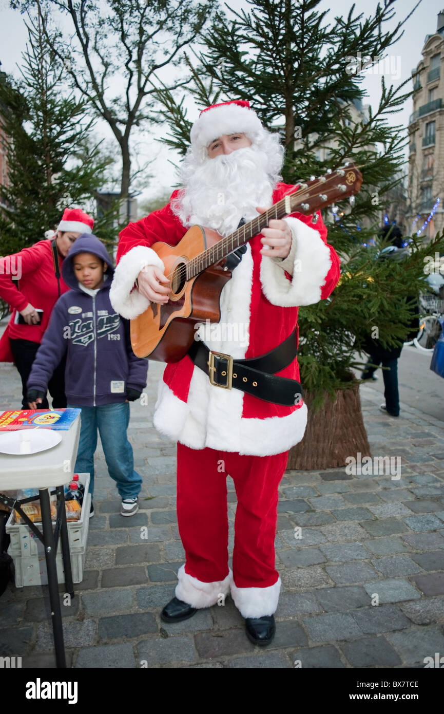 Parigi, Francia, Celebrazioni di Natale per i bambini con Babbo Natale, cantando "Pere Noël', fuori strada Foto Stock