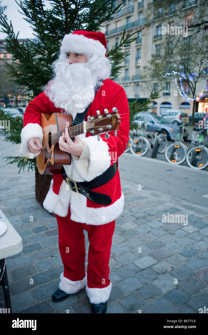 Parigi, Francia, feste di Natale, Babbo Natale, Pere Noël, suonare chitarra e canto, fuori strada, Babbo natale da solo Foto Stock