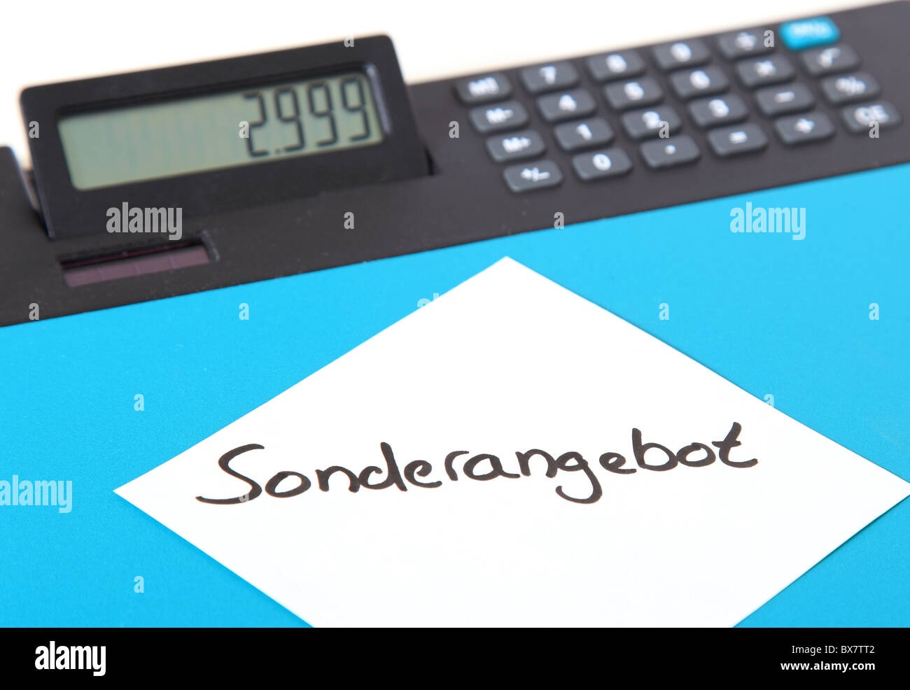 Pezzo di carta che mostra la mostra il termine tedesco Sonderangebot (inglese: offerta speciale) giacente su un calcolatore Foto Stock