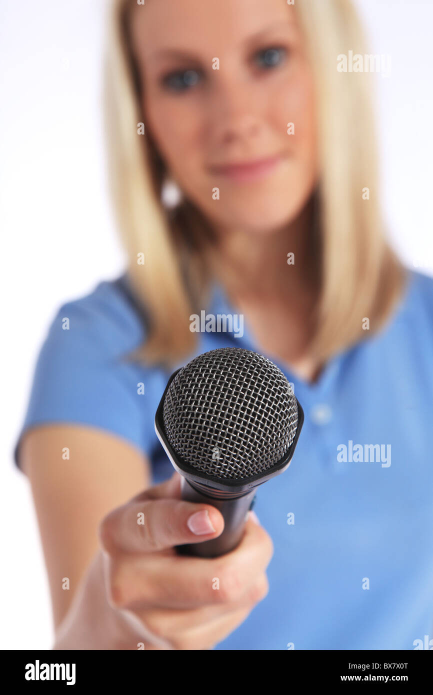 Attraente giovane intervistatore tenendo un microfono. Messa a fuoco selettiva sul microfono in primo piano. Tutto su sfondo bianco. Foto Stock