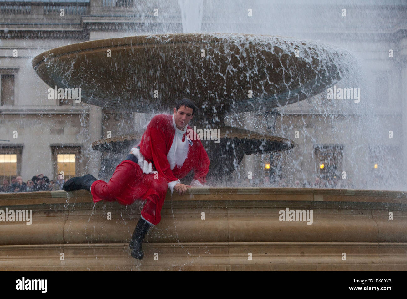 Santacon 2010, flashmob raduno di persone vestite come Santa nel centro di Londra. Santa in Trafalgar Square fontana. Foto Stock