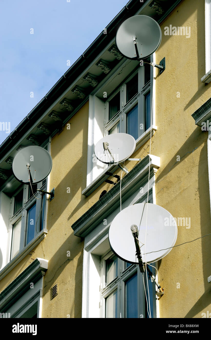 Piastre di satellite su un edificio residenziale di facciata Foto Stock