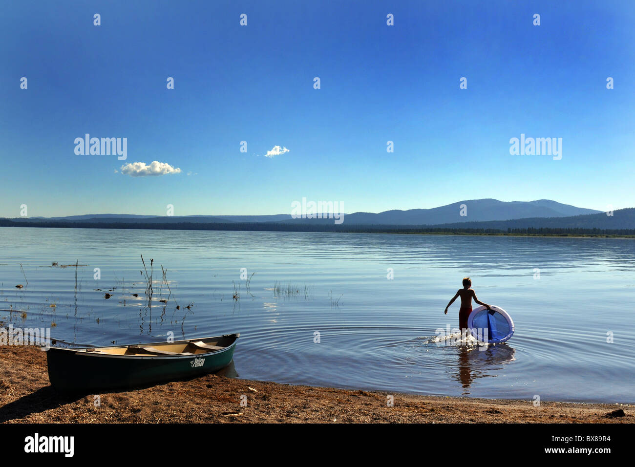 Un ragazzo bagna in acqua per raffreddare, Lago Almanor, California USA Foto Stock