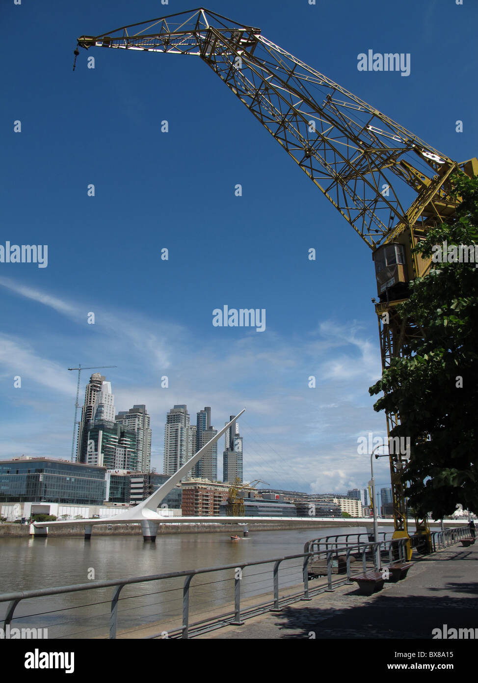 Un vecchio, restaurato gru presso il bacino di Puerto Madero, Buenas Aires, con la moderna passerella girevole e moderni edifici Foto Stock