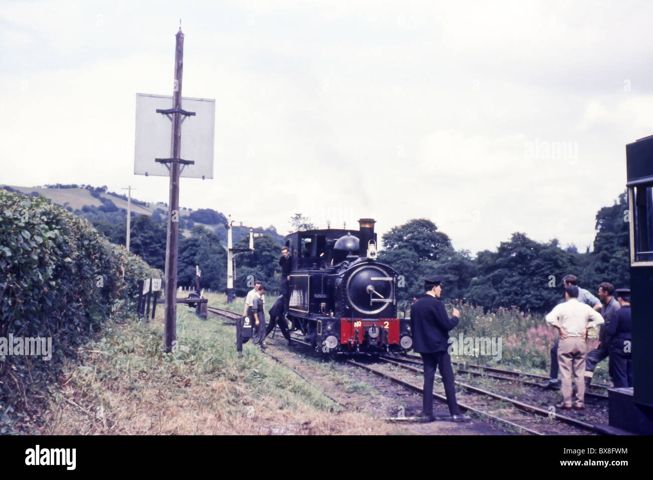 Un originale degli anni sessanta immagine di una locomotiva a vapore treno stata sistemata in posizione da parte del personale e di turisti. Foto Stock