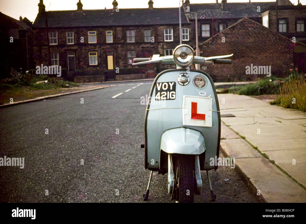 Original 60'simmagine di uno scooter/ciclomotore parcheggiato fino a lato della strada in una terrazza house. Foto Stock