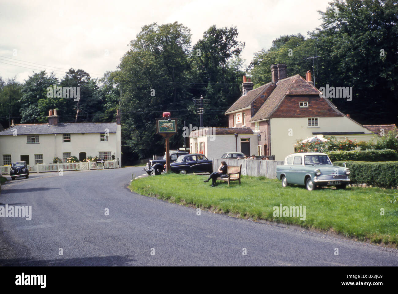 Una fotografia originale degli anni '1960 del pub Hare & Hounds a Framfield, nell'East Sussex, che mostra auto d'epoca e cottage in un villaggio rurale. Foto Stock