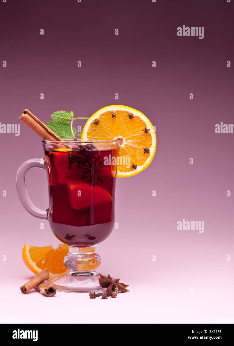 Bicchiere di vin brulé su uno sfondo rosa Foto Stock