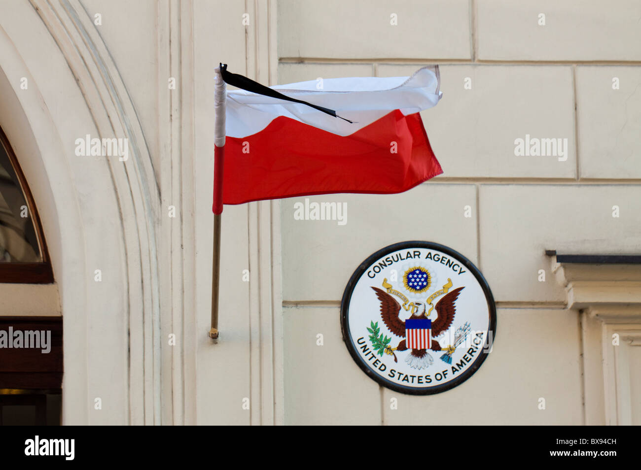 Bandiera polacca con un nastro di lutto appeso al consolato americano a Poznan, Polonia Foto Stock