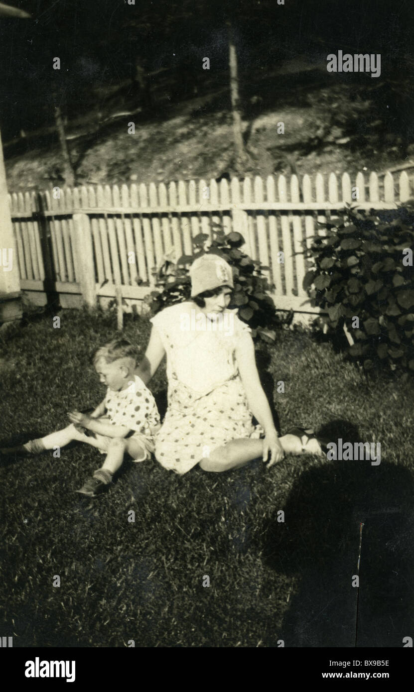 La madre e il bambino sul prato accanto al white Picket Fence America all'aperto di moda piuttosto hat polka dots matching al di fuori Foto Stock
