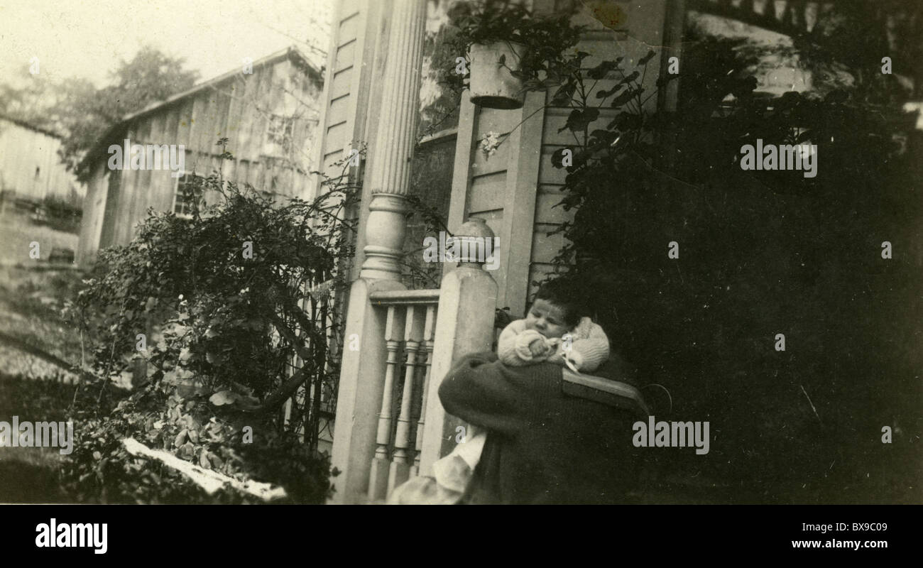 Genitore in possesso di bambino fuori casa in legno sulla fattoria. Americana in bianco e nero Foto Stock
