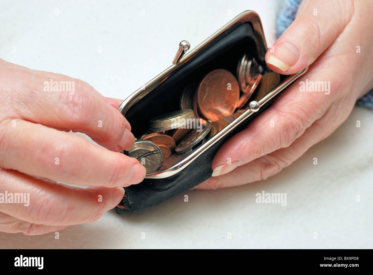 Titolare di pensione o di rendita tenendo aperto il borsellino con moneta cambia all'interno di Inghilterra Regno Unito Foto Stock