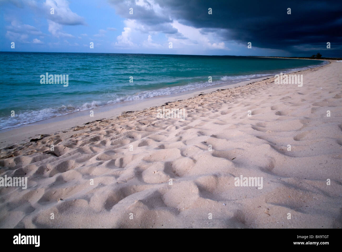 Spiaggia di sabbia bianca e splendide acque sotto un minaccioso cielo tempestoso a Cayo Santa-Maria, Cuba. Foto Stock