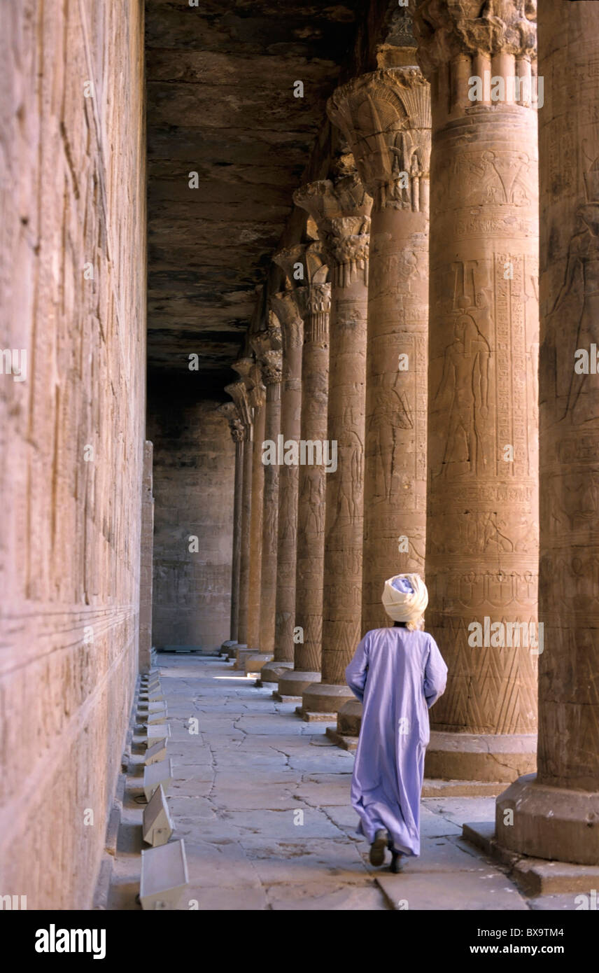 Tempio di Edfu, Edfu, Egitto - uomo vestito in abiti tradizionali a piedi in tra le colonne Foto Stock