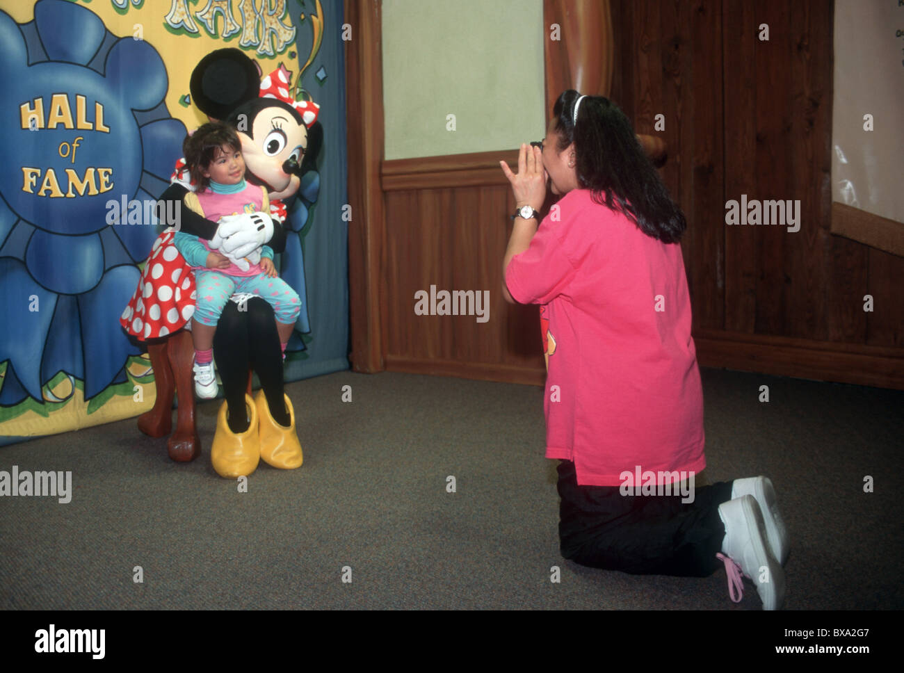 USA.I VISITATORI DEL HALL OF FAME abbracciando Mickey Mouse in Disney in Orlando Florida Foto Stock