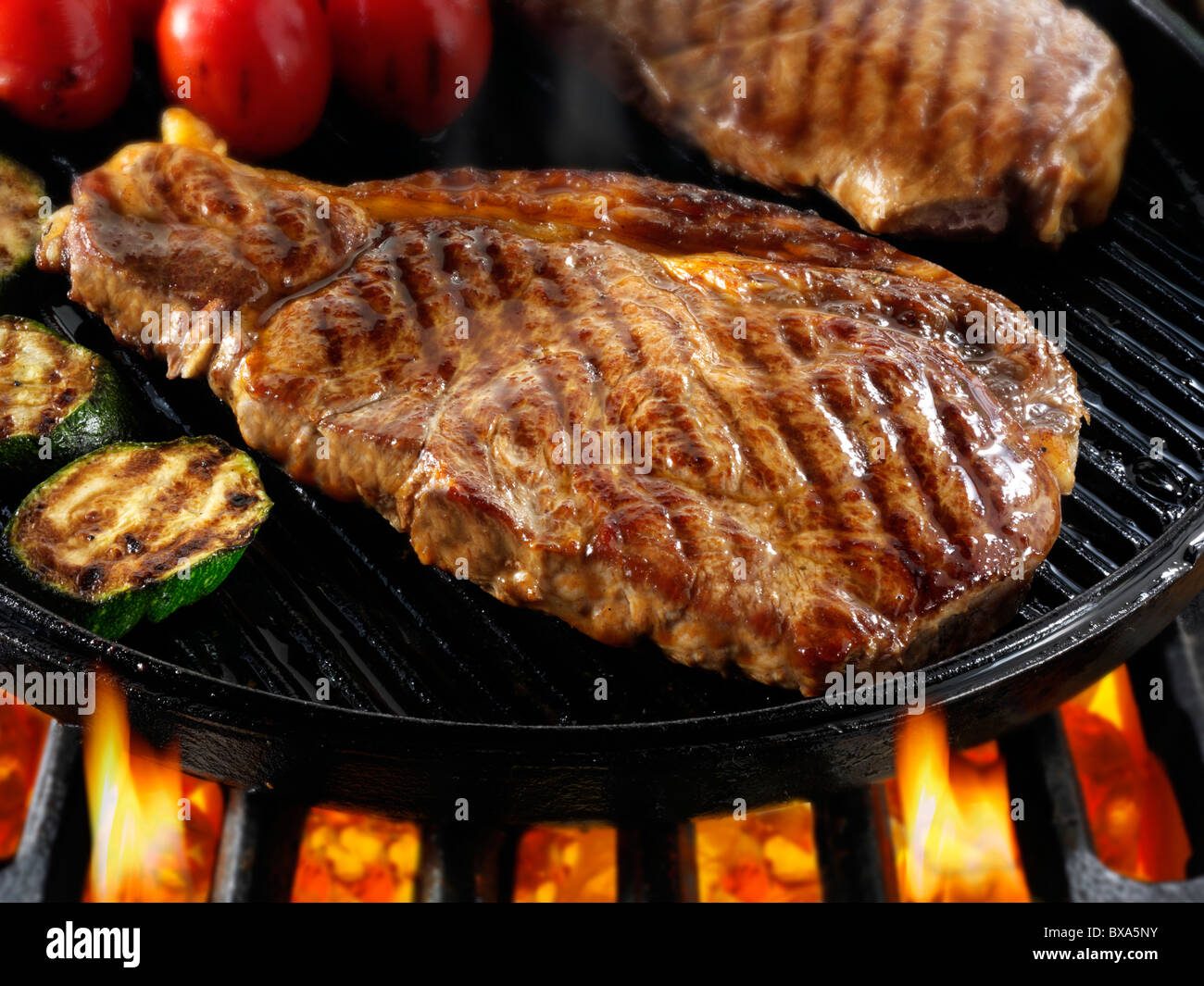 Controfiletto di bistecche di manzo e pomodori in padella fritto su un barbecue. Alimenti a base di carne le foto, foto e immagini. Foto Stock