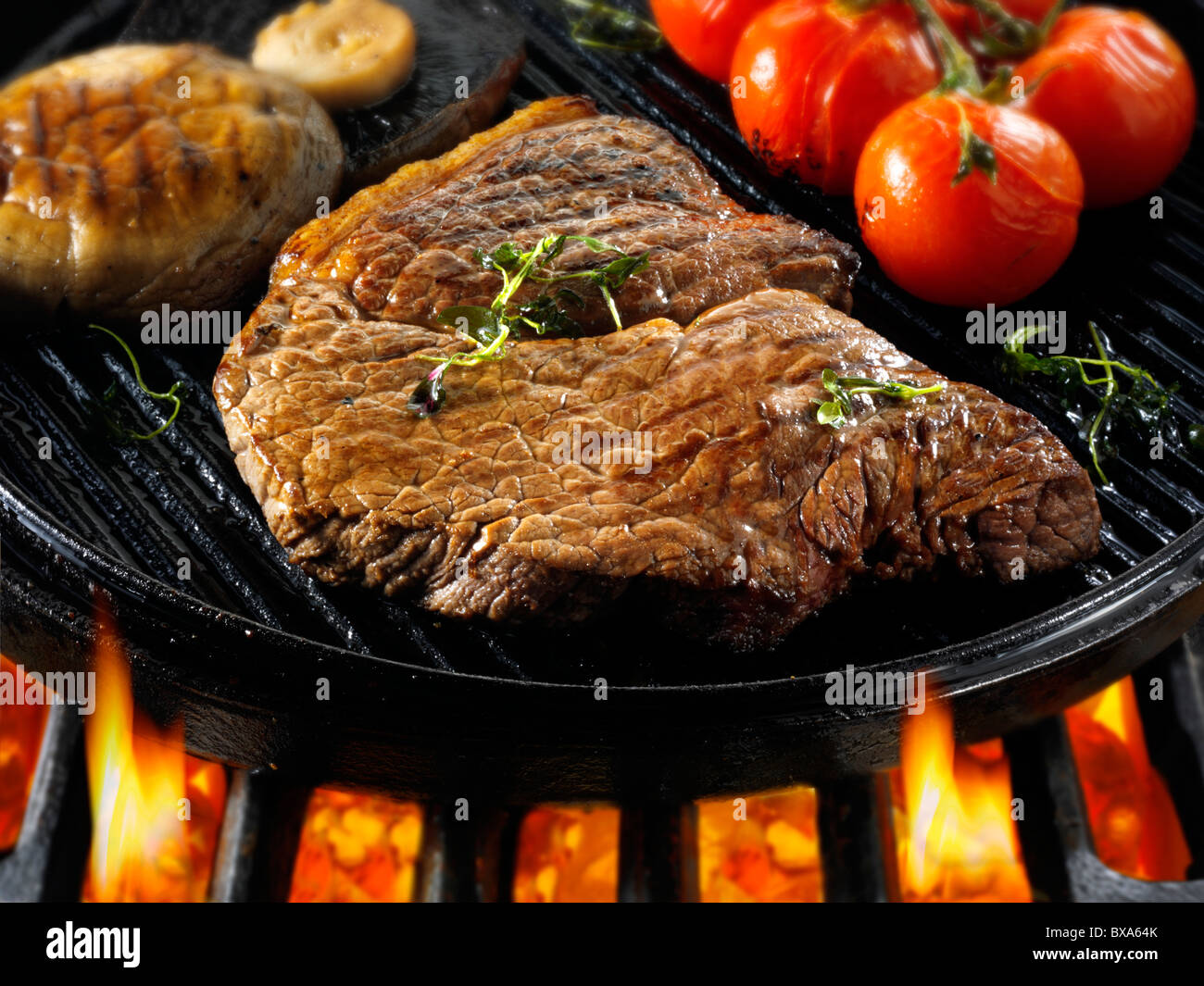 Carni bovine bistecche e pomodori in padella fritto su un barbecue. Alimenti a base di carne le foto, foto e immagini. Foto Stock
