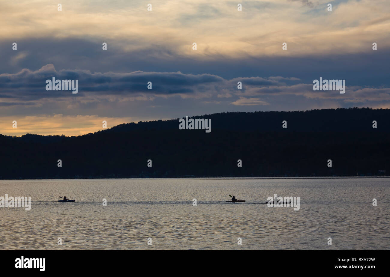 Kayakers al tramonto nel quarto lago vicino l'ingresso nelle Montagne Adirondack di New York Foto Stock