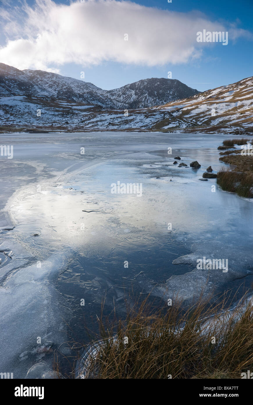 Congelati Styhead tarn in inverno con Lingmell e Scafell Pike al di là, Lake District, Cumbria Foto Stock