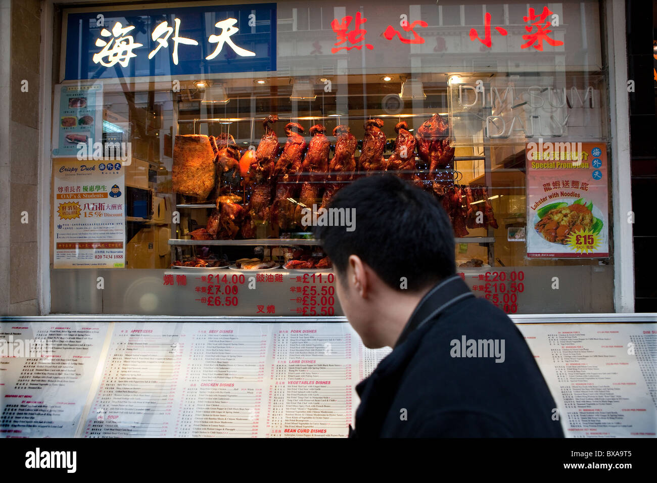 Uomo di lettura al di fuori del menu del ristorante cinese China Town, Londra Foto Stock