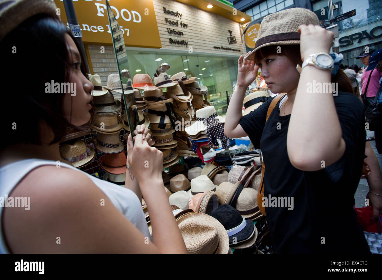 La donna sta cercando su un cappello in Seoul department store, Corea del Sud Foto Stock