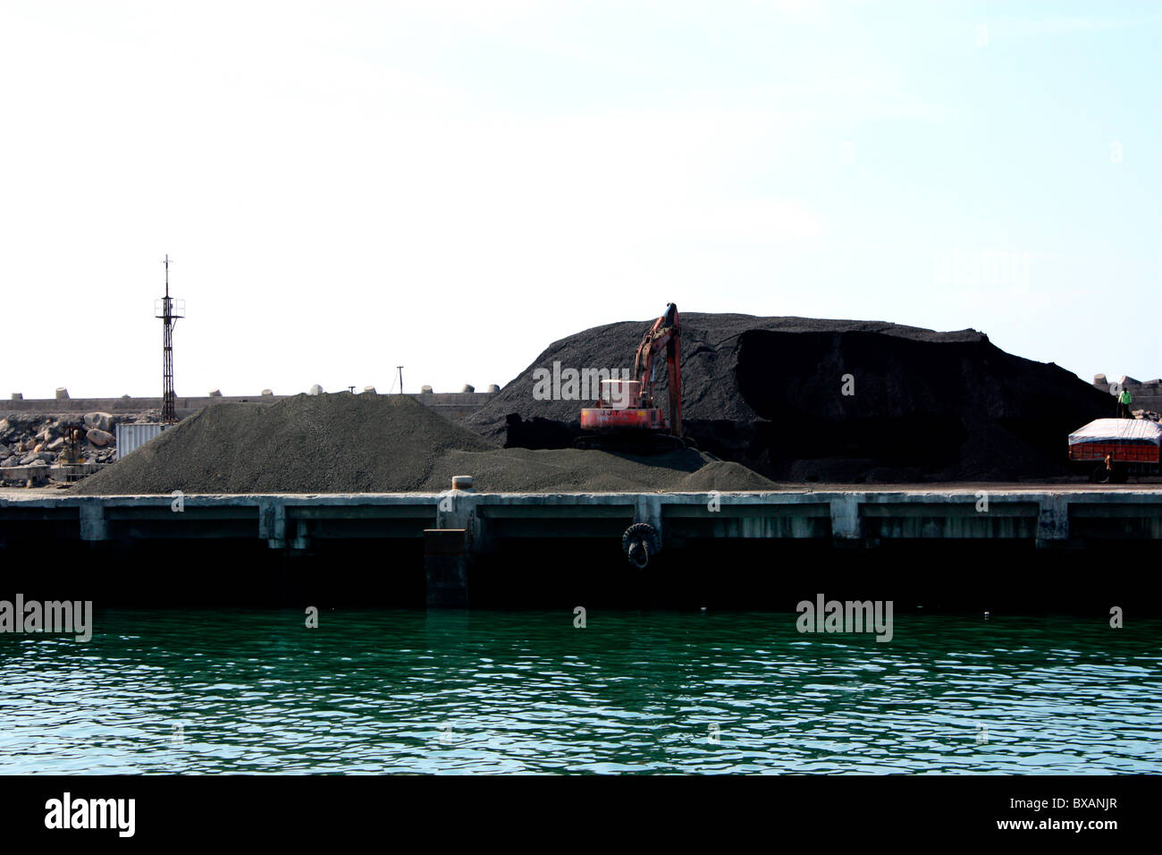 Dumping sulle importazioni di minerali di ferro a Porbandar port Foto Stock