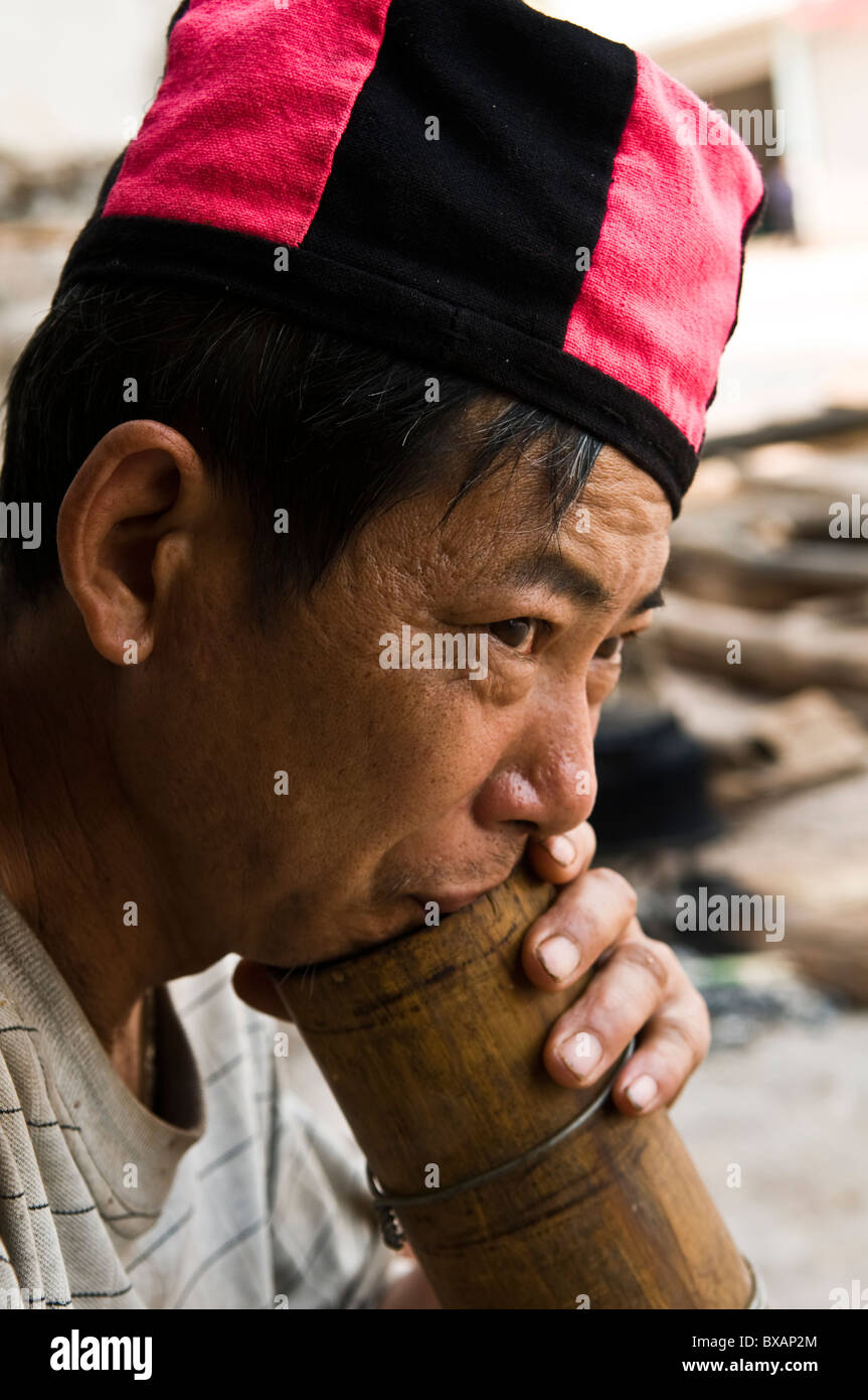 Un Yao uomo tabacco da fumo con un tradizionale tubo di bambù. Foto Stock