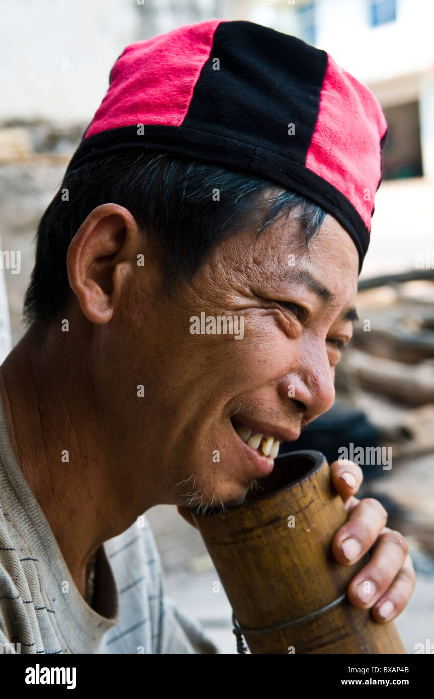 Un Yao uomo tabacco da fumo con un tradizionale tubo di bambù. Foto Stock