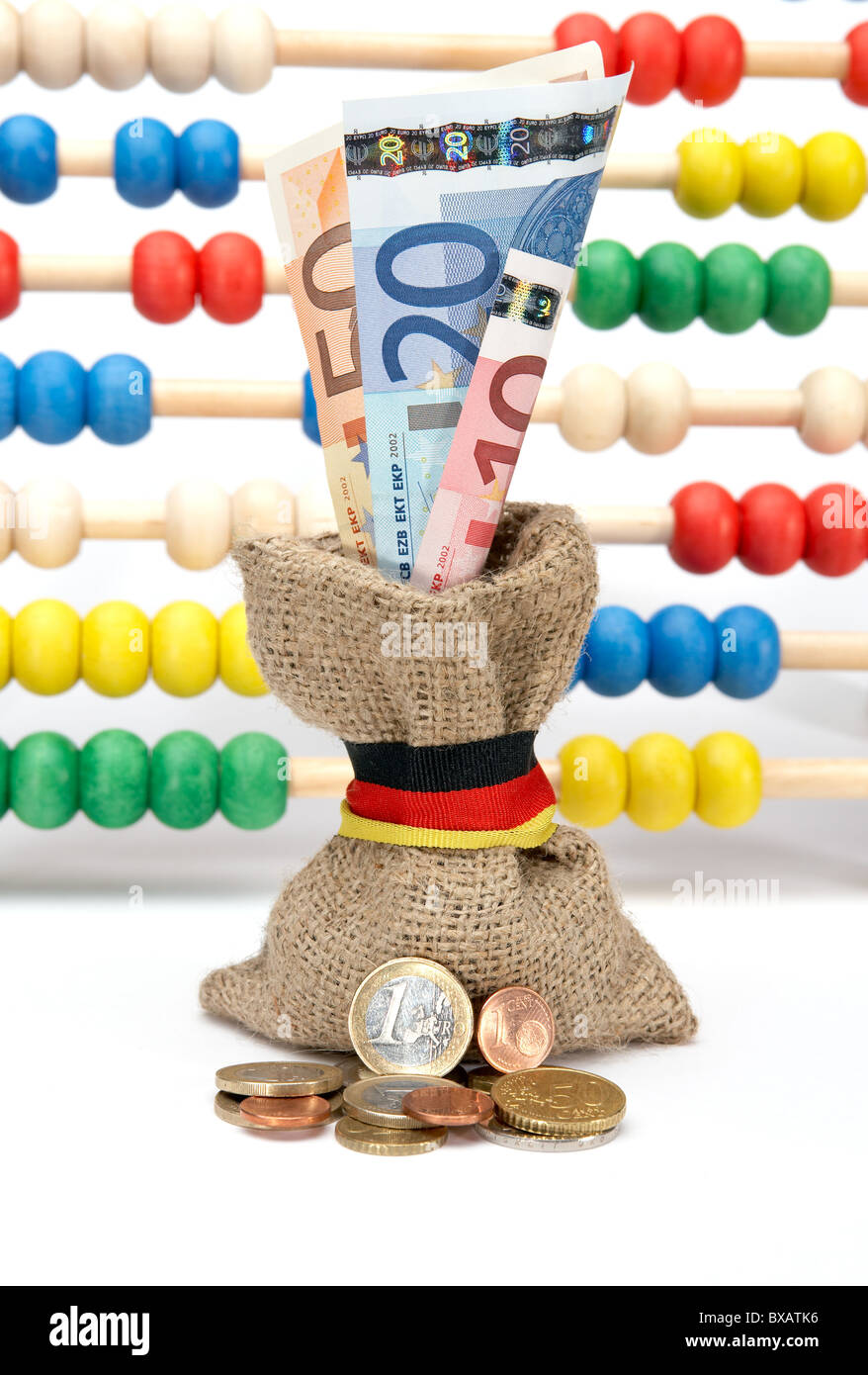Monete di fronte un po' grossolana del sacco di iuta con le banconote in euro Foto Stock