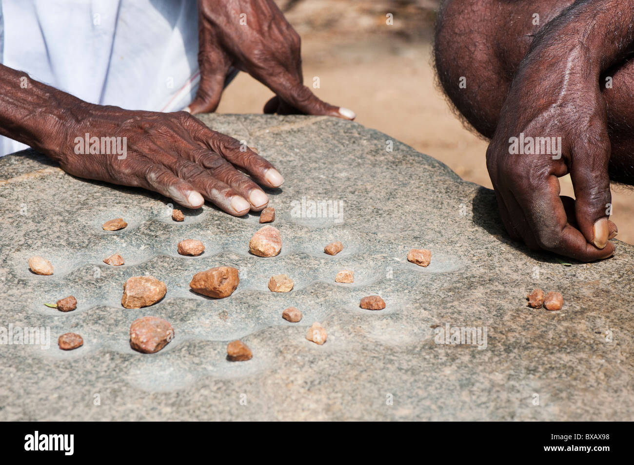 Vecchio gioco come bozze giocato con le pietre da indian uomini in un territorio rurale villaggio indiano. Andhra Pradesh, India Foto Stock